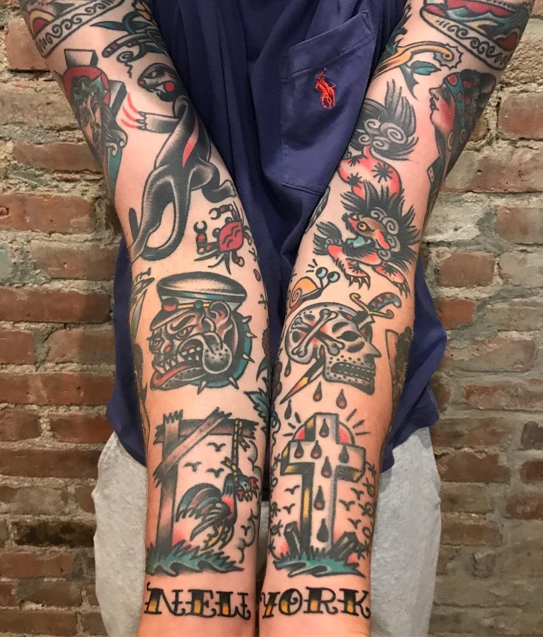 A person displaying multiple colorful American traditional tattoos covering both of their arms.
