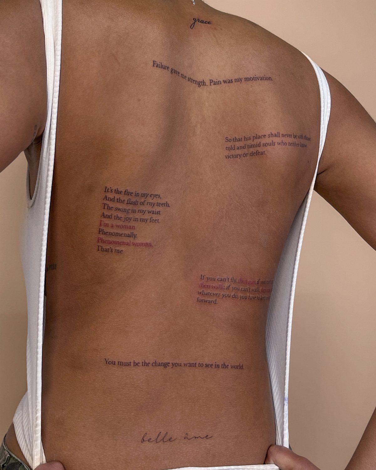7 Back Tattoo Writing Ideas for Lettering That Lasts 5 A person's back featuring several small, delicate fine line text tattoos in various locations.