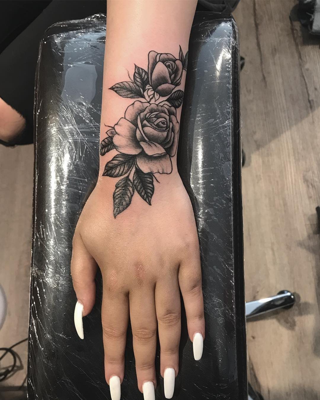 12 Easy Tattoo Drawings For Beginners, From Hearts to Tribal Flash 5 Black and grey rose tattoo with leaves on a person's hand and wrist.