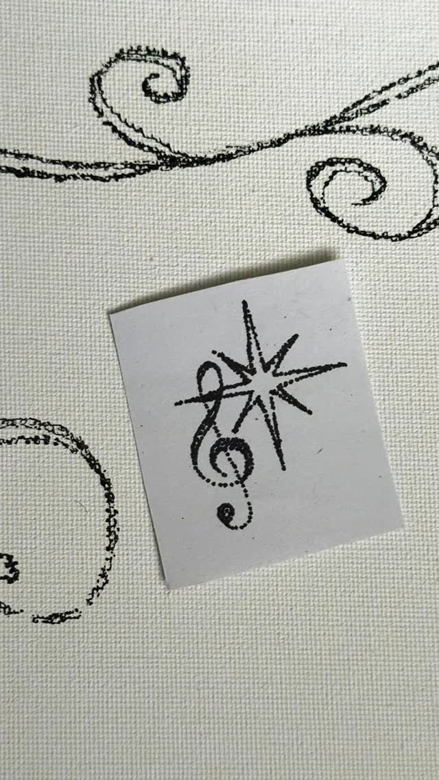 12 Easy Tattoo Drawings For Beginners, From Hearts to Tribal Flash 11 A small paper with a black ink treble clef and star drawing on white fabric.