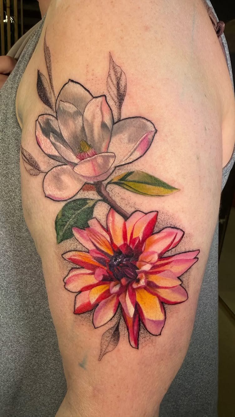 13 Large Flower Tattoo Ideas for Your Next Big Bloom 9 A large colorful tattoo of a white magnolia and an orange dahlia on a person's arm.