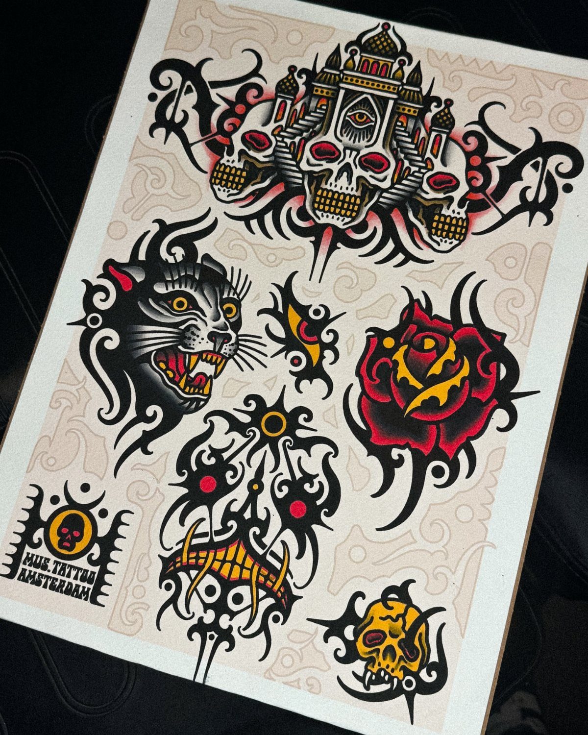 Tattoo flash sheet featuring black and red ink designs of skulls, a panther, and a rose.