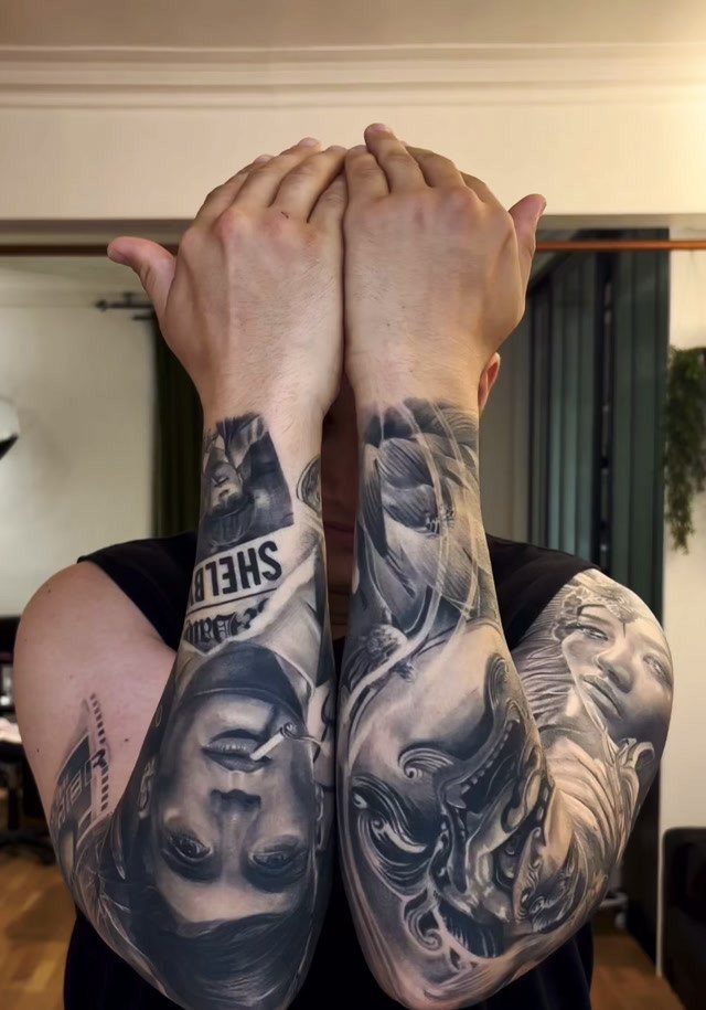 Detailed black and grey realism tattoos covering a person's entire arms from wrist to shoulder.