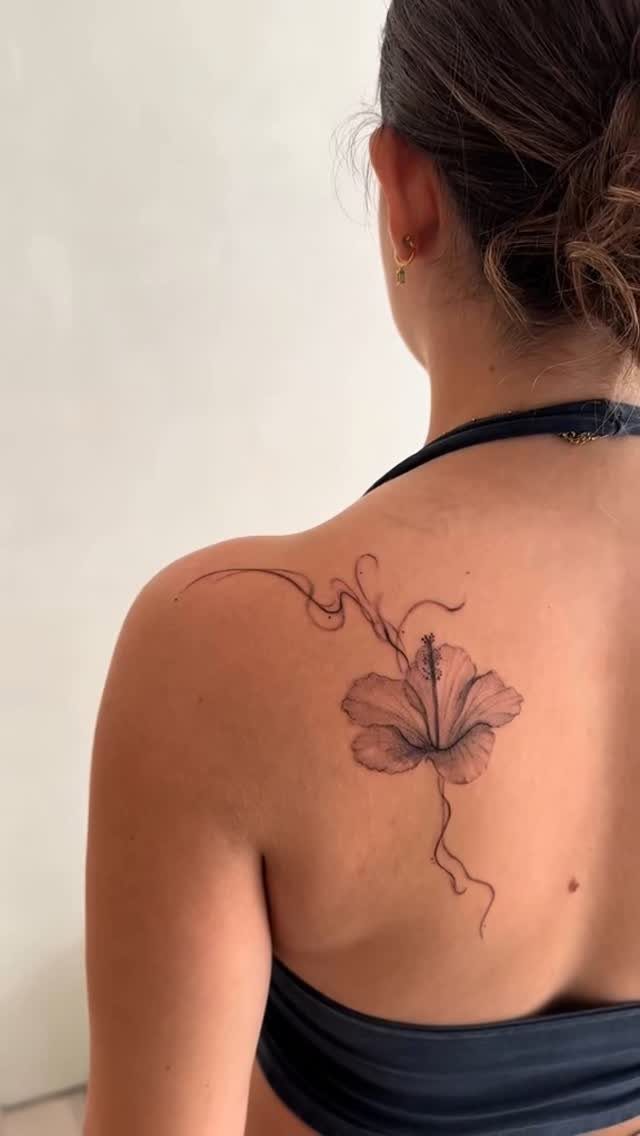 22 Tattoo Pattern Floral Ideas for Arms, Ribs & Full Sleeves 8 A hibiscus flower tattoo with fine lines on a person's upper back.