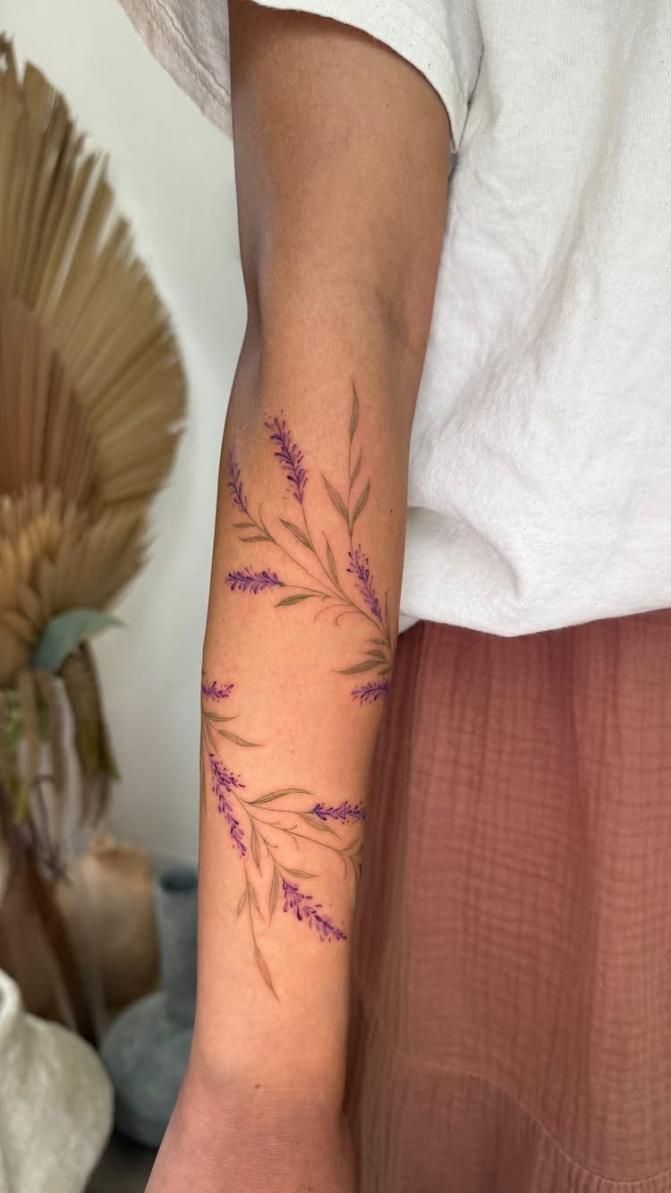 22 Tattoo Pattern Floral Ideas for Arms, Ribs & Full Sleeves 9 Lavender sprig tattoos in purple and green ink on a person's forearm.