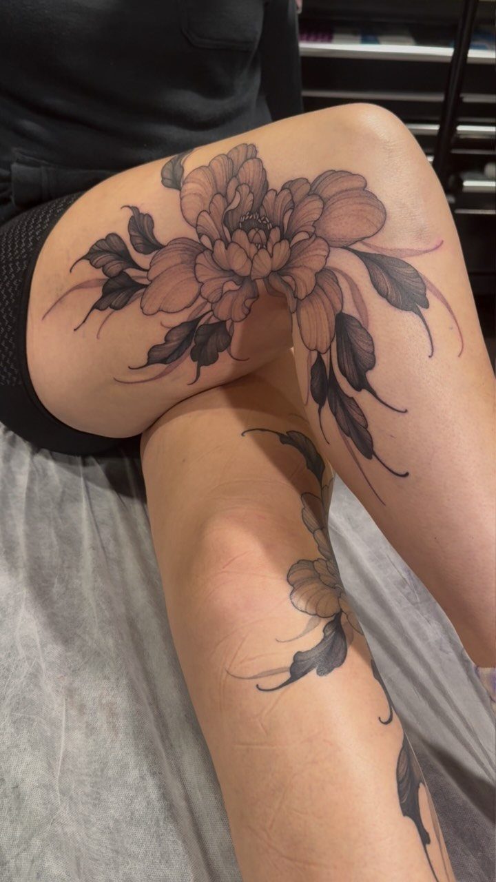 22 Tattoo Pattern Floral Ideas for Arms, Ribs & Full Sleeves 4 Large black and grey peony floral tattoo on a person's thigh and leg.