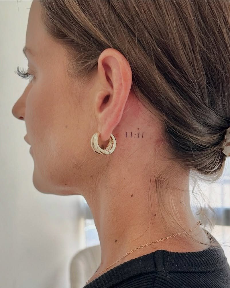 A woman's profile showing a small number tattoo behind her ear.