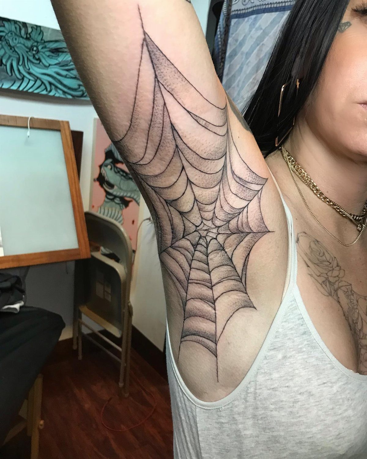 A large spiderweb tattoo located on a person's underarm area.