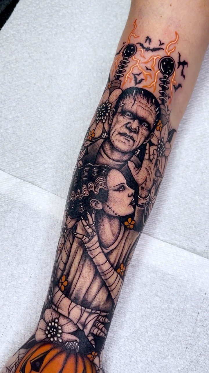 Frankenstein and Bride of Frankenstein characters tattooed on a person's forearm with lightning bolts.