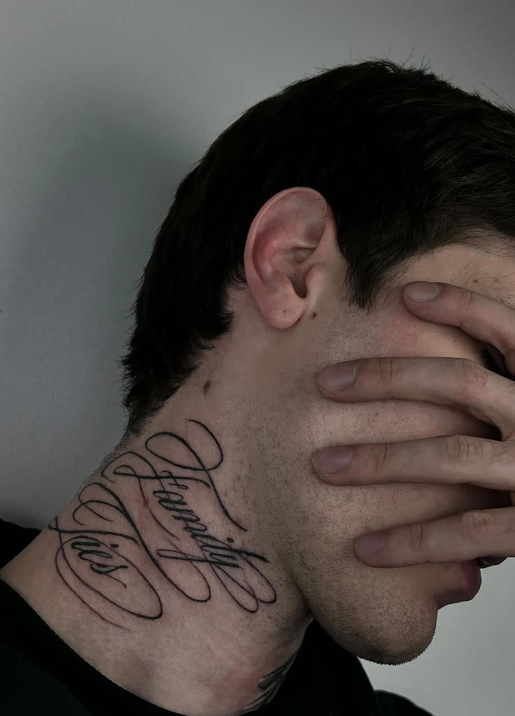 A man with a cursive text tattoo on his neck reading Family First.
