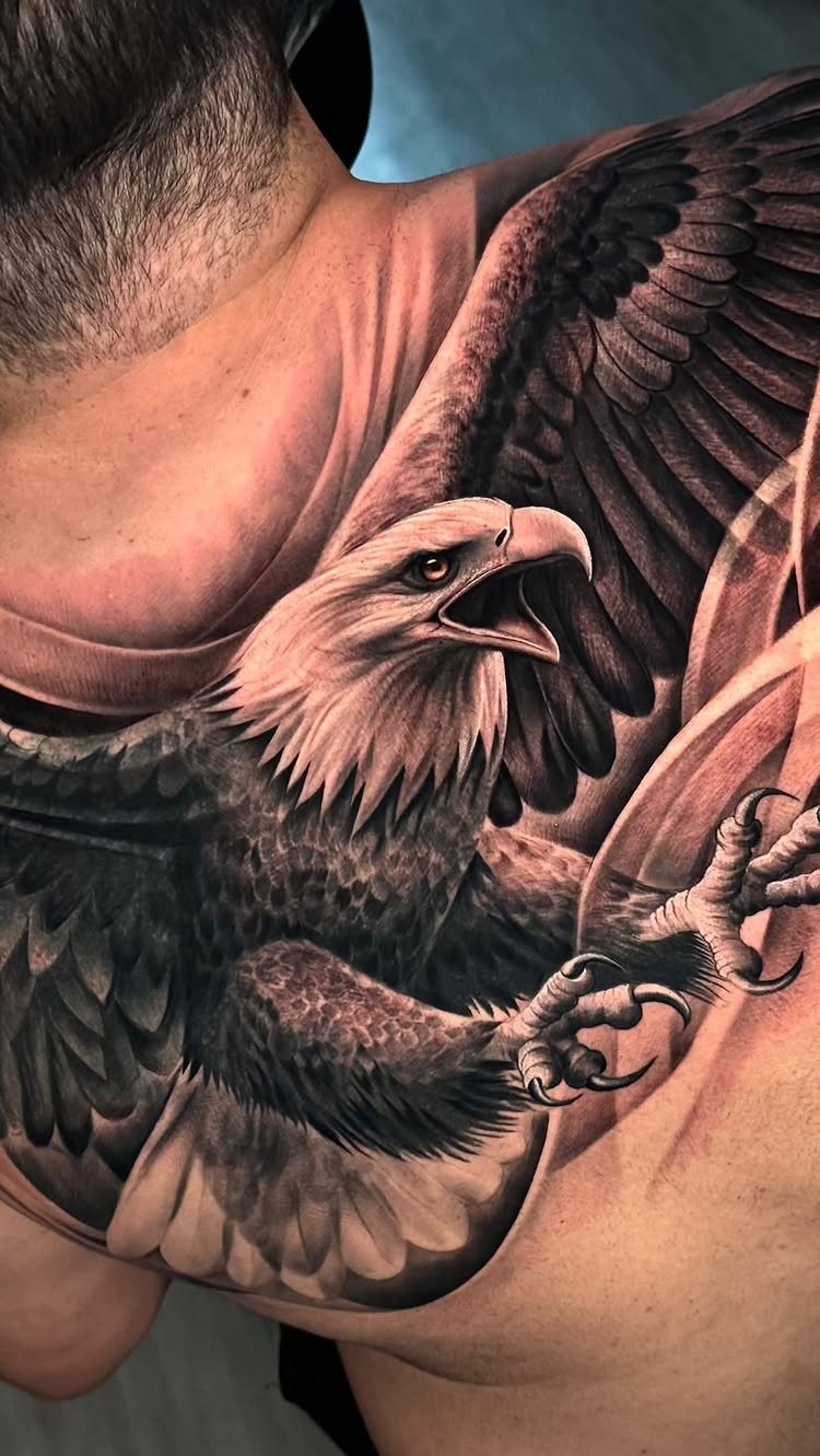 A large realistic bald eagle tattoo on a man's shoulder and chest.